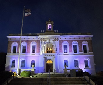 City Hall at night with two lanterns up in the balcony