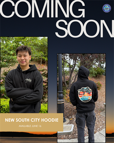 Young man wearing the new South City hoodie outside with greenery as his backdrop