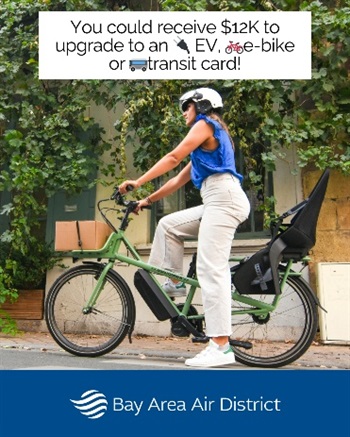 A person in a blue shirt and khakis and white helmet riding a green e-bike