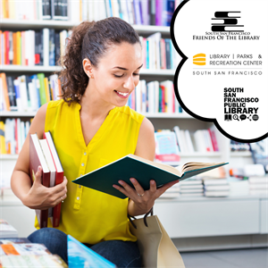 A young woman in a yellow shirt reading a book in a room of books