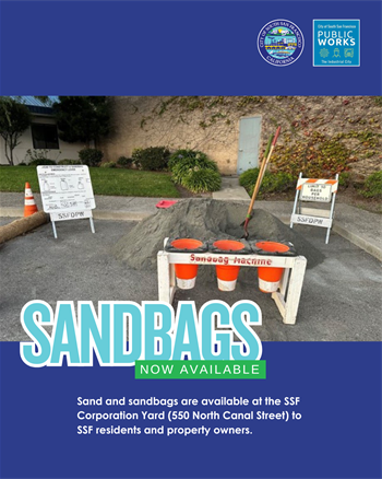 Sandbags outside of the Public Works Department. Piles of sand, bags, and a shovel.