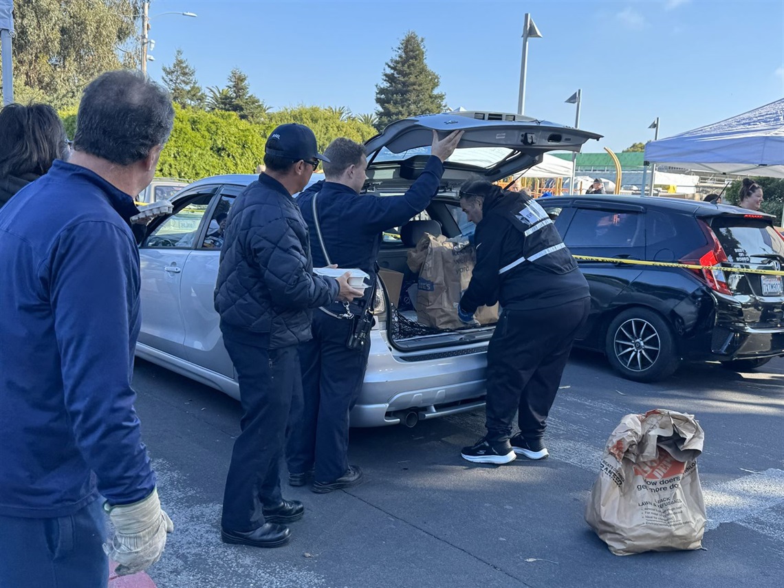 Firefighters and volunteers loading a vehicle with bags of food outside the Fernekes building