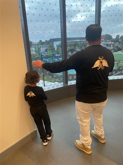 Jesus Pena and son looking at Sign Hill with Juliana's photo on their sweaters