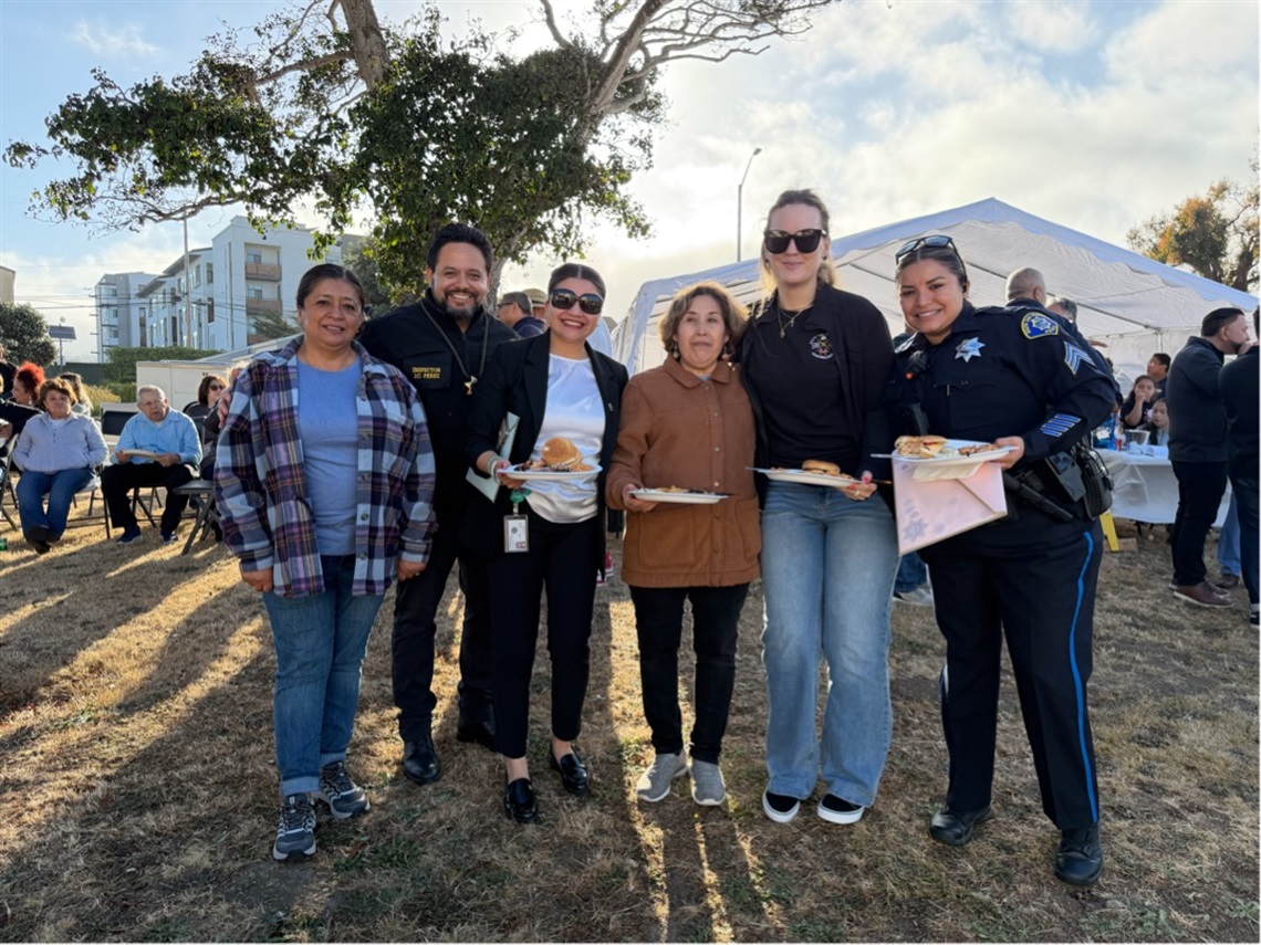 Police officers standing with residents outside during National Night Out