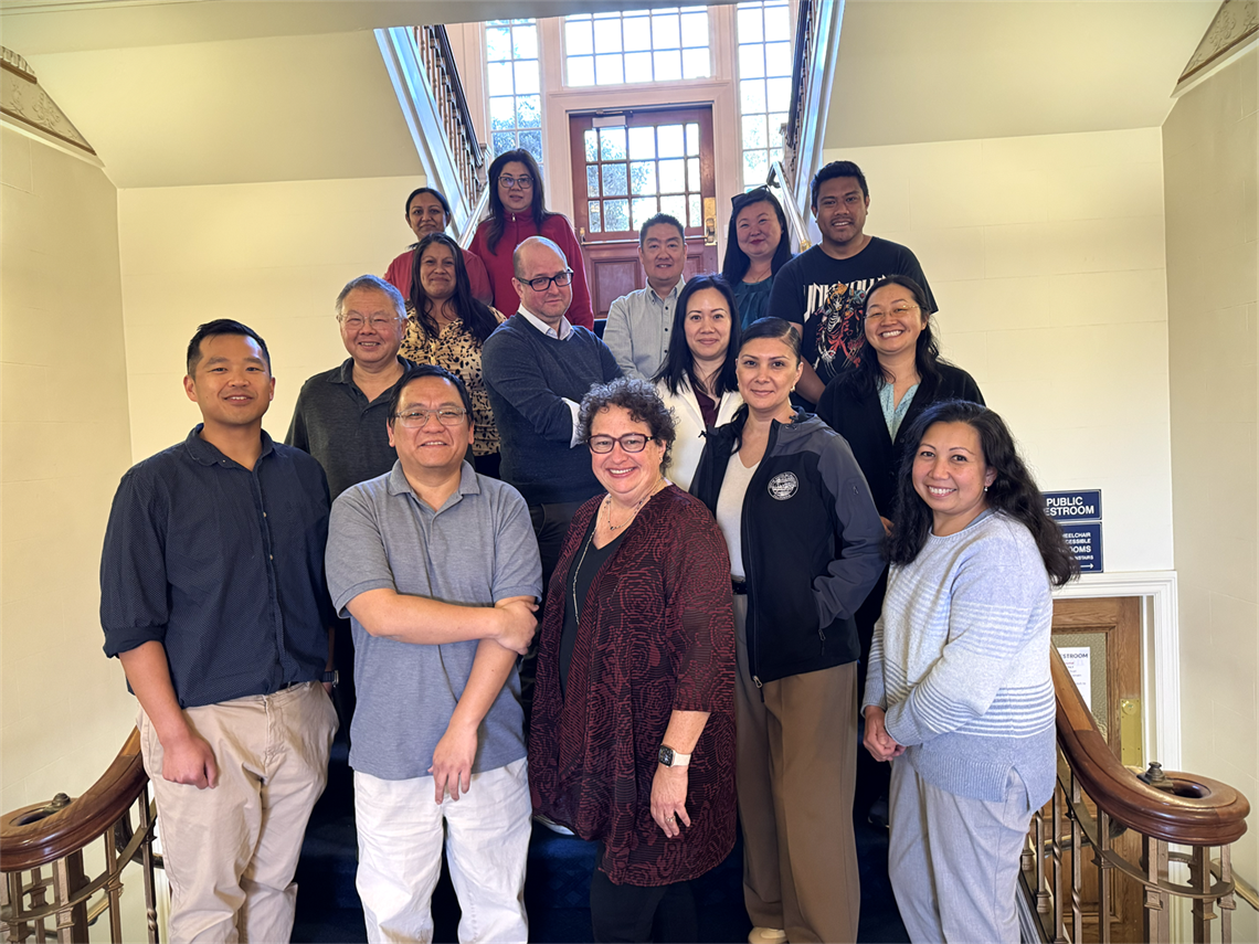 The Finance Team standing on the stairs inside City Hall
