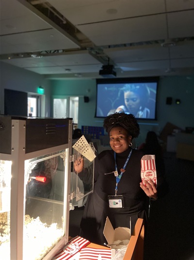 staff in front of movie screen and popcorn maker