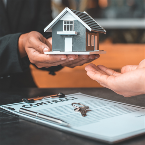 Handing over a miniature house.