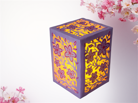 Image of a cricut luminary with cherry blossoms on the luminary and in the background