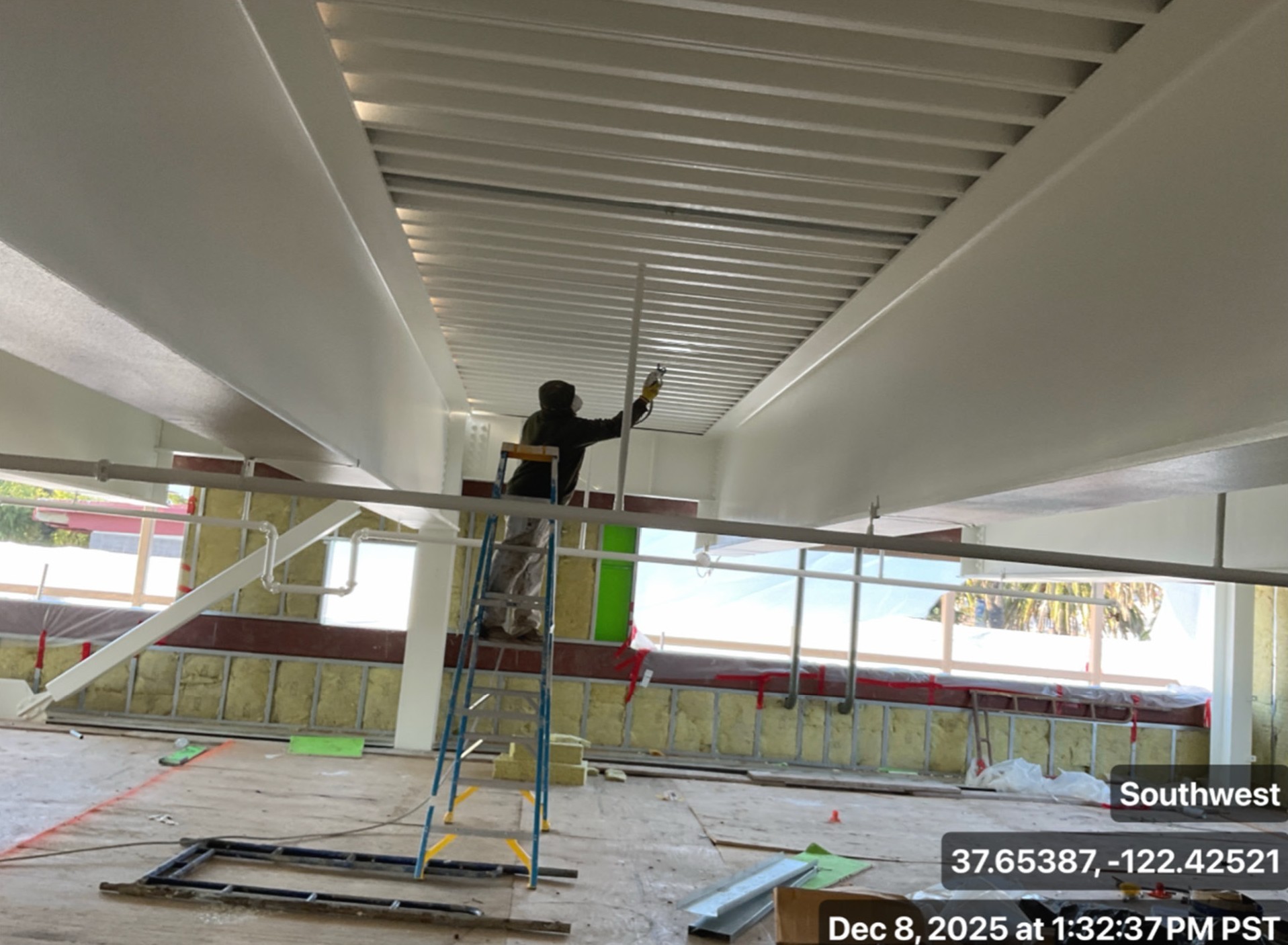 worker painting natatorium ceiling
