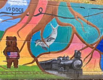 painting of tree roots, locomotive, bear, harbor seal, U.S. flag