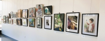 Many different painting hanging on a wall