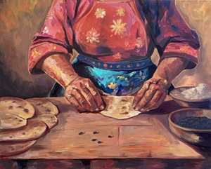 woman shaping dough on a wooden table top