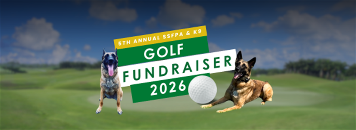 Two police K9s sitting on a golf course with a golf ball