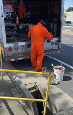 Man in orange suit fabricating storm drain capture