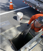 Man in orange suit installing storm drain